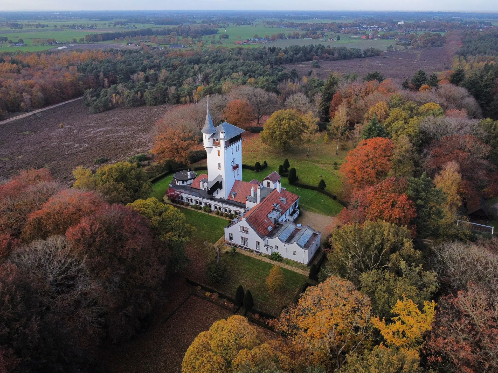 Drone luchtfoto van een kasteel omgeven door herfstbomen in Friesland door MVDBmedia